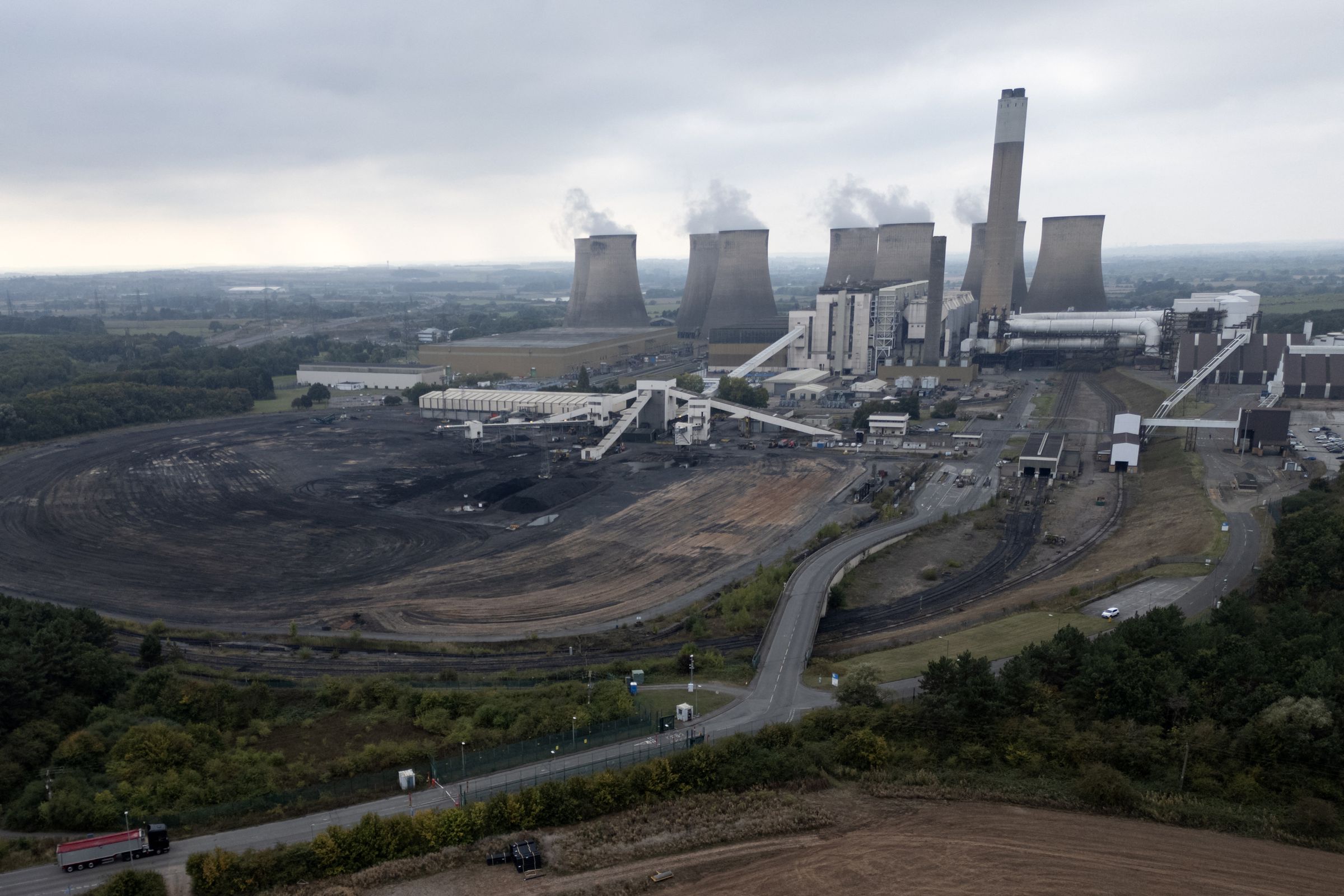 A picture shows an aerial view of the Ratcliffe-on-Soar coal-fired power station, including smokestacks with emissions billowing out of them.