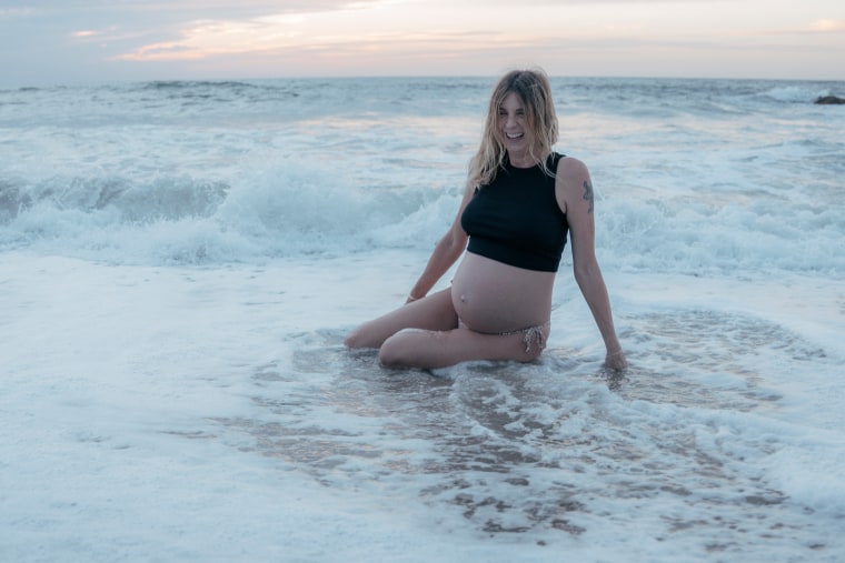 Jennifer Nosek, pregnant, smiles in the ocean, in Mexico.