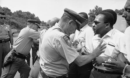 Mississippi Highway Patrolmen shove the Rev Martin Luther King and members of his marching group off the traffic lane of Highway 51 south of Hernando, Mississippi on 7 June 1966.