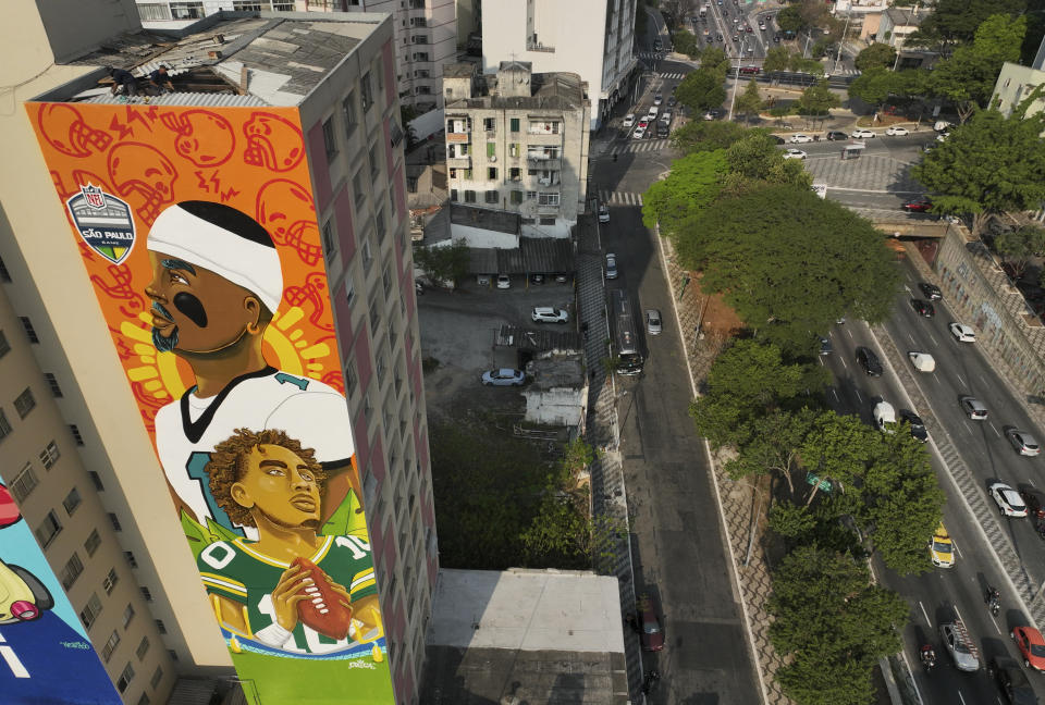 A mural created by artist Crica featuring Philadelphia Eagles quarterback Jalen Hurts and Green Bay Packers quarterback Jordan Love adorns an apartment building in downtown Sao Paulo. (AP Photo/Andre Penner)