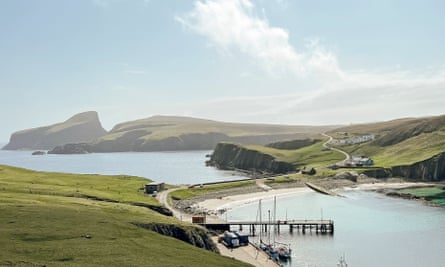 A view on a sunny day pf pale blue skies and two bays divided by a narrow strip of land.