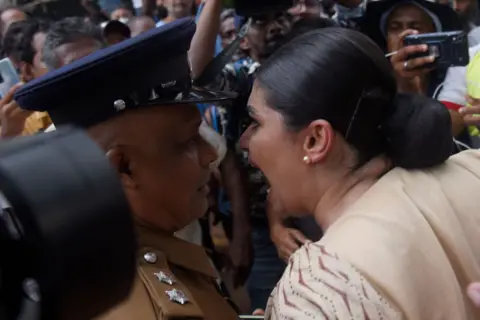 Getty Images A women in a crowd shouts into the face of an officer 