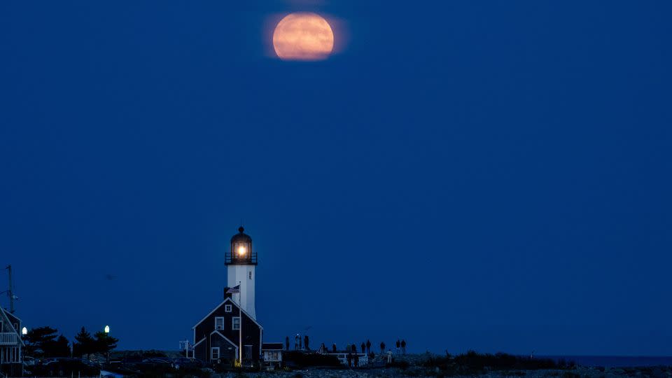 The harvest moon, a full supermoon, shines over Scituate Lighthouse in Scituate, Massachusetts, on Tuesday. - Joseph Prezioso/Anadolu Agency/Getty Images