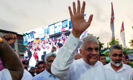 Ranil Wickremesinghe waves with a stadium of people behind him