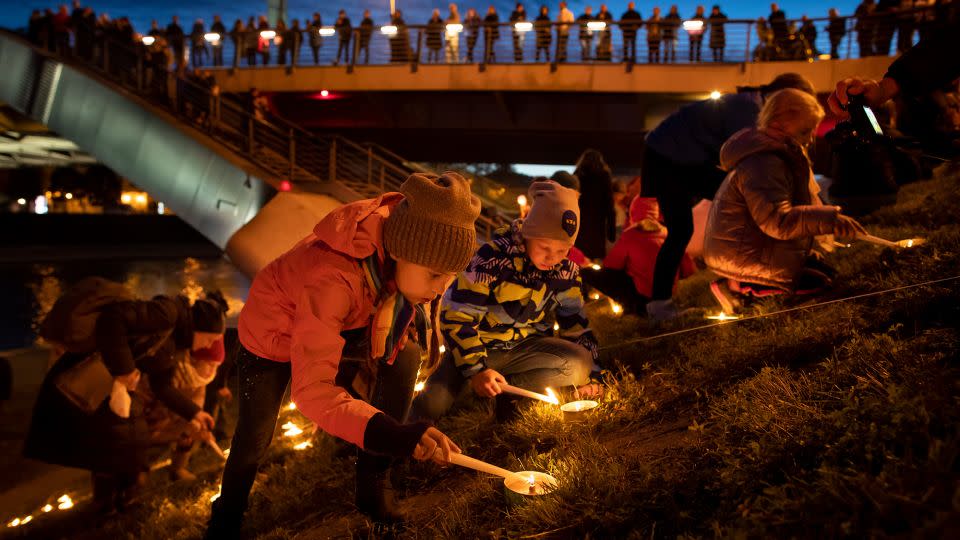 People participate in rituals during a fall equinox celebration on an embankment of the Neris River near King Mindaugas' Bridge in Vilnius, Lithuania, in 2019. - Mindaugas Kulbis/AP