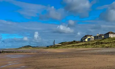 The beach at Seascale, where the nuclear site of Sellafield can be seen close to the coastal town  