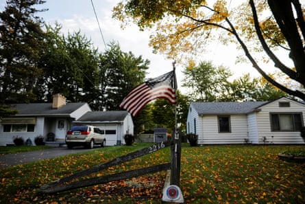 an American flag waves in the wind outside a home