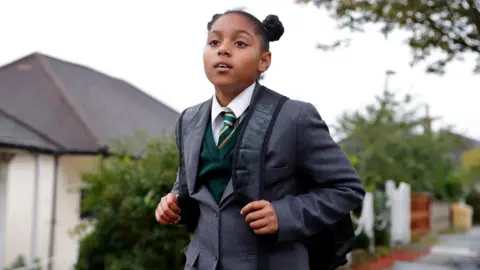 Getty Images Girl aged 10 walking on residential street, wearing blazer