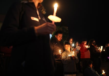 Nighttime outdoors image of people holding candles.