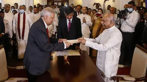 Getty Images Ranil Wickremesinghe swears in Dinesh Gunawardena as his prime minister in 2022