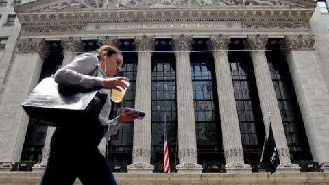 Getty Images  A woman walks near the New York Stock Exchange on July 18, 2023 in New York City.