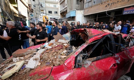 Journalists gather at the scene of a building that was hit by an Israeli airstrike in Beirut’s southern suburbs.