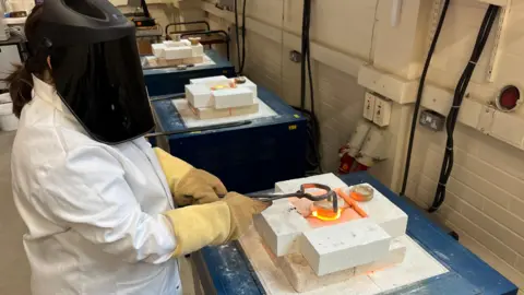 A nuclear materials researcher making glass in a laboratory 