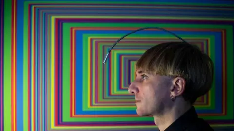 Getty Images Neil Harbisson with an artwork featuring colourful rectangles