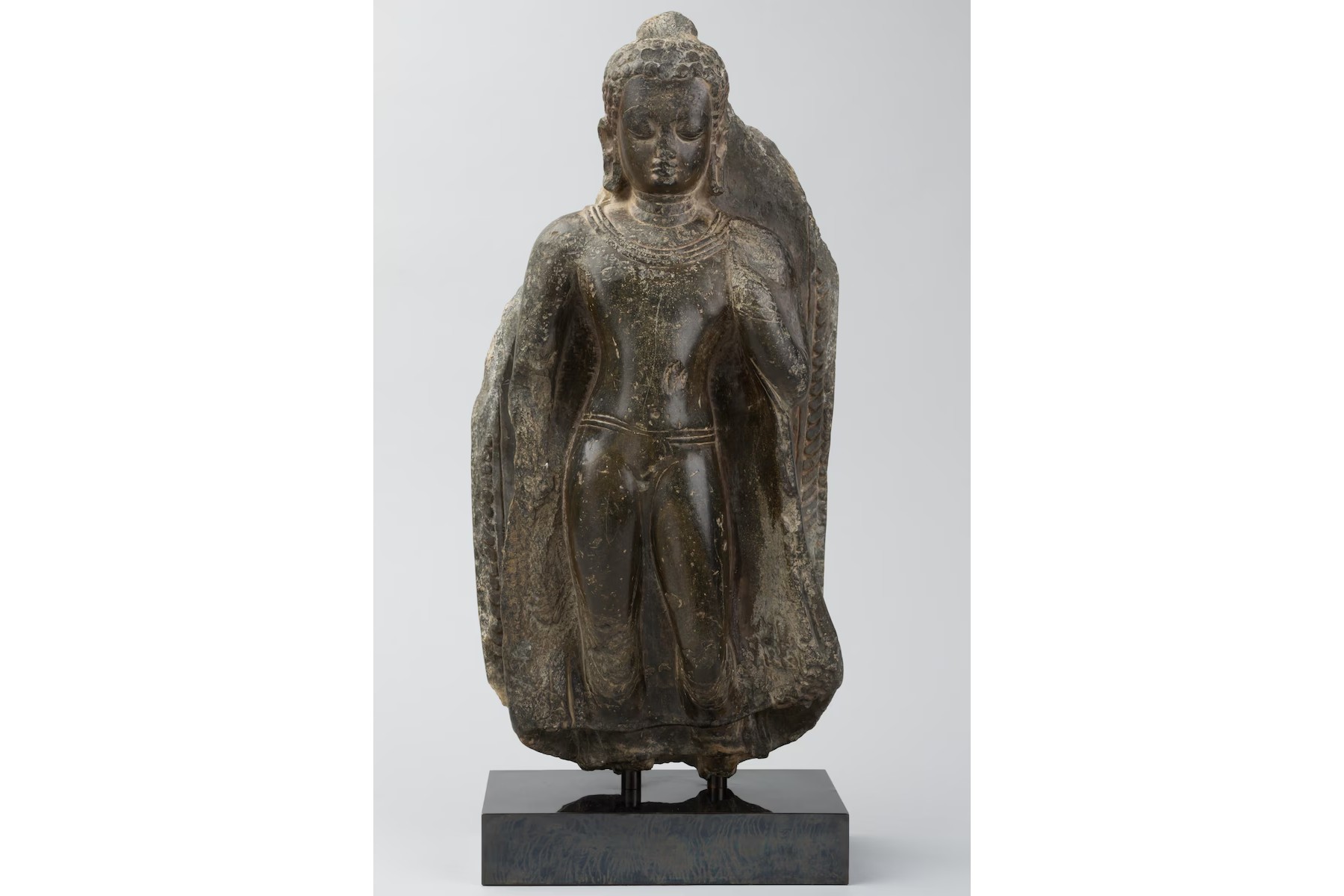 An 18-inch black stone statue of Buddha from the 9th century. The statue has been identified for deaccession by the University of Michigan's Museum of Art.