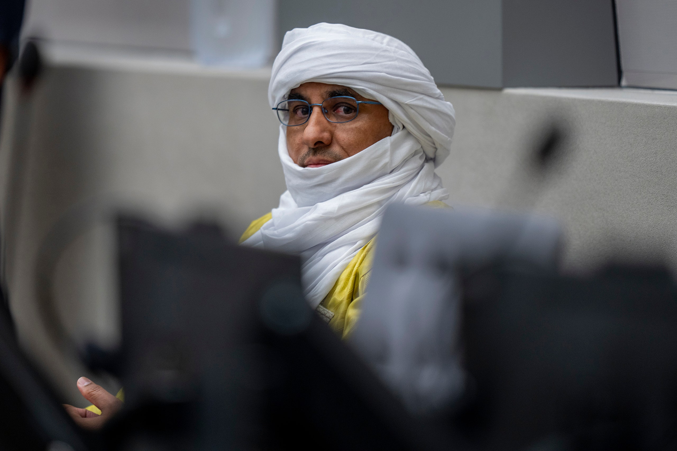 Al Hassan Ag Abdoul Aziz Ag Mohamed Ag Mahmoud waits for judges to enter the courtroom of the International Criminal...