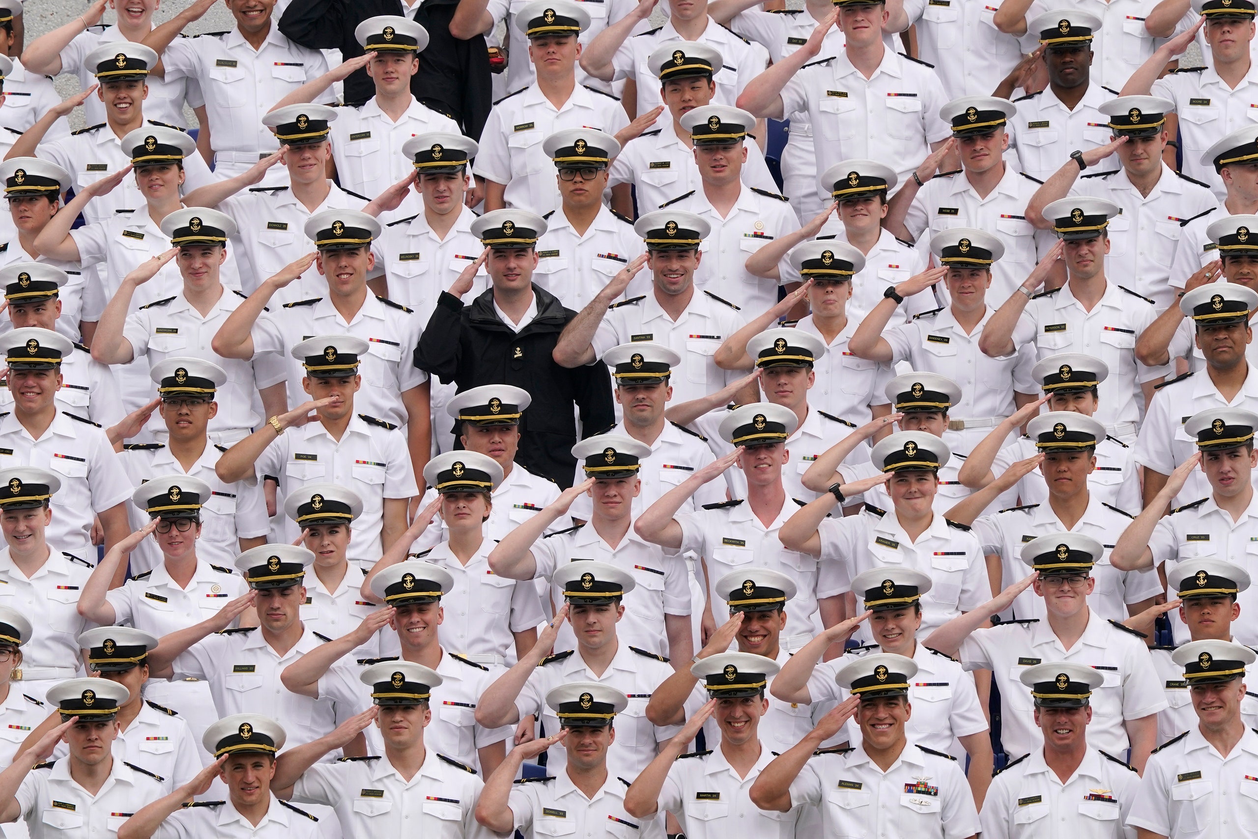 A group of uniformed military people saluting.