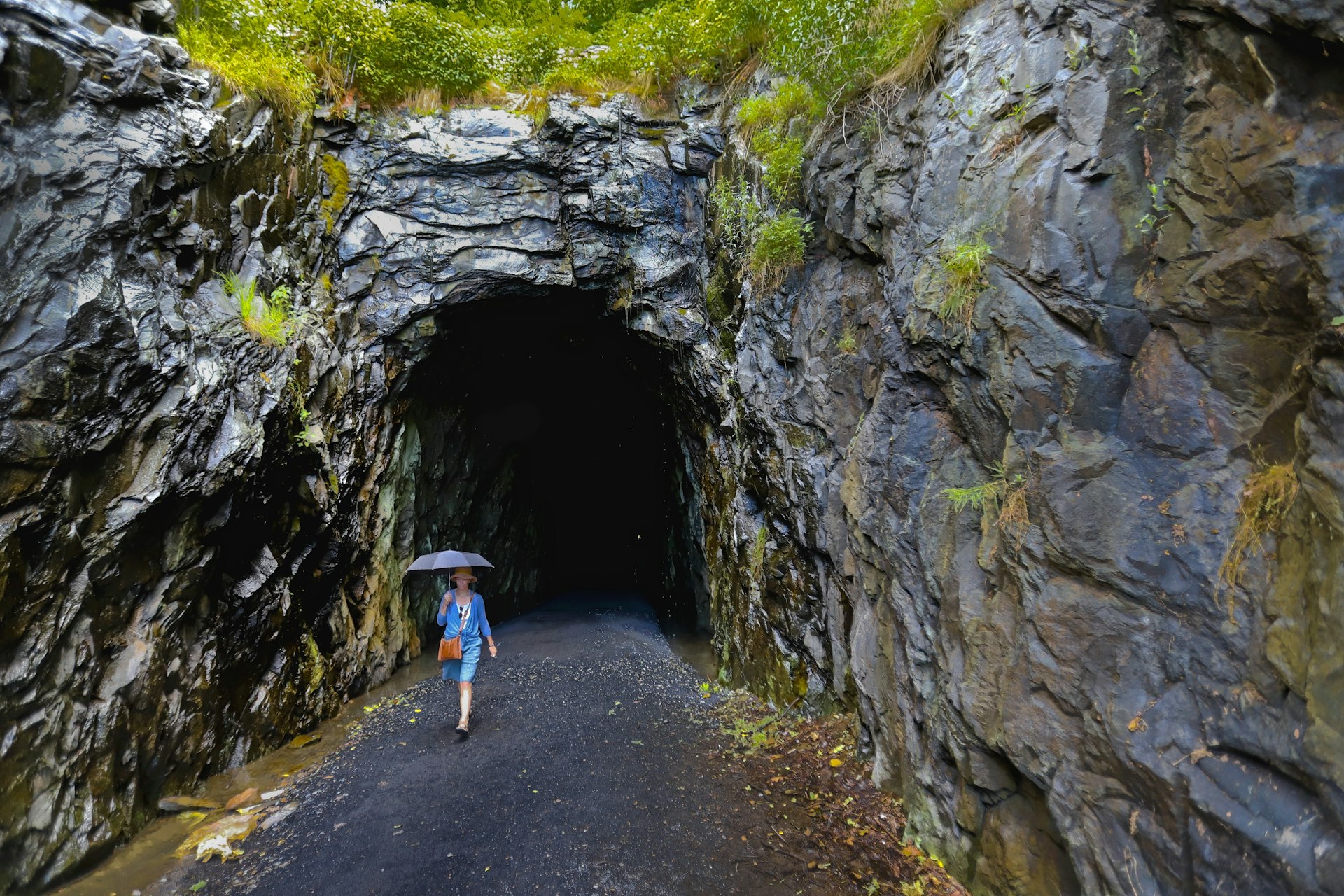 Woman With Umbrella exiting former railroad tunnel now the  Blue Ridge Tunnel East Trailhead.