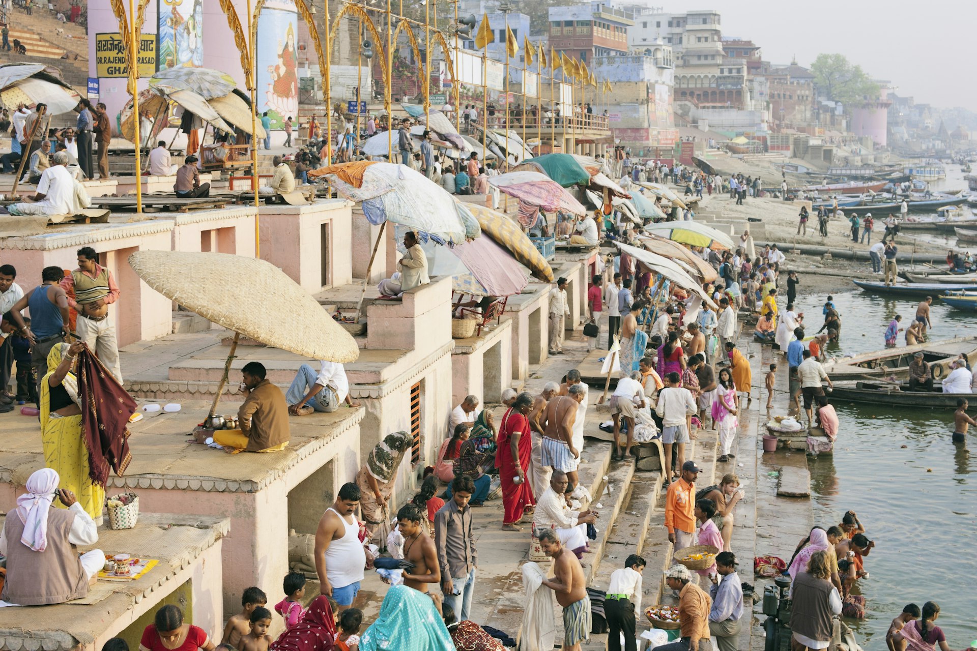 Hindus bathing and praying by the Ganges river on the steps of Dasaswamedh Ghat, Varanasi, India