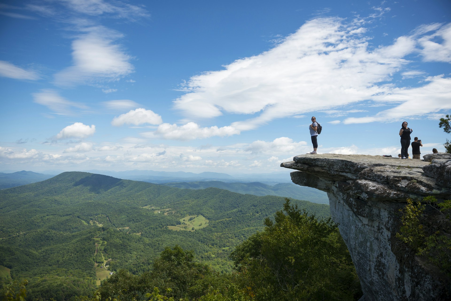 Hikers take in the view of the Appalachian Mountains from McAfee Knob on Catawba Mountain.