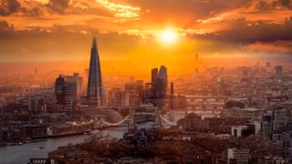 A beautiful sunset behind the London skyline with Tower Bridge, River Thames and the corporate skyscrapers.