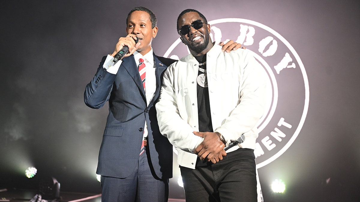 Shyne wraps his arm around Sean Diddy Combs at a concert.