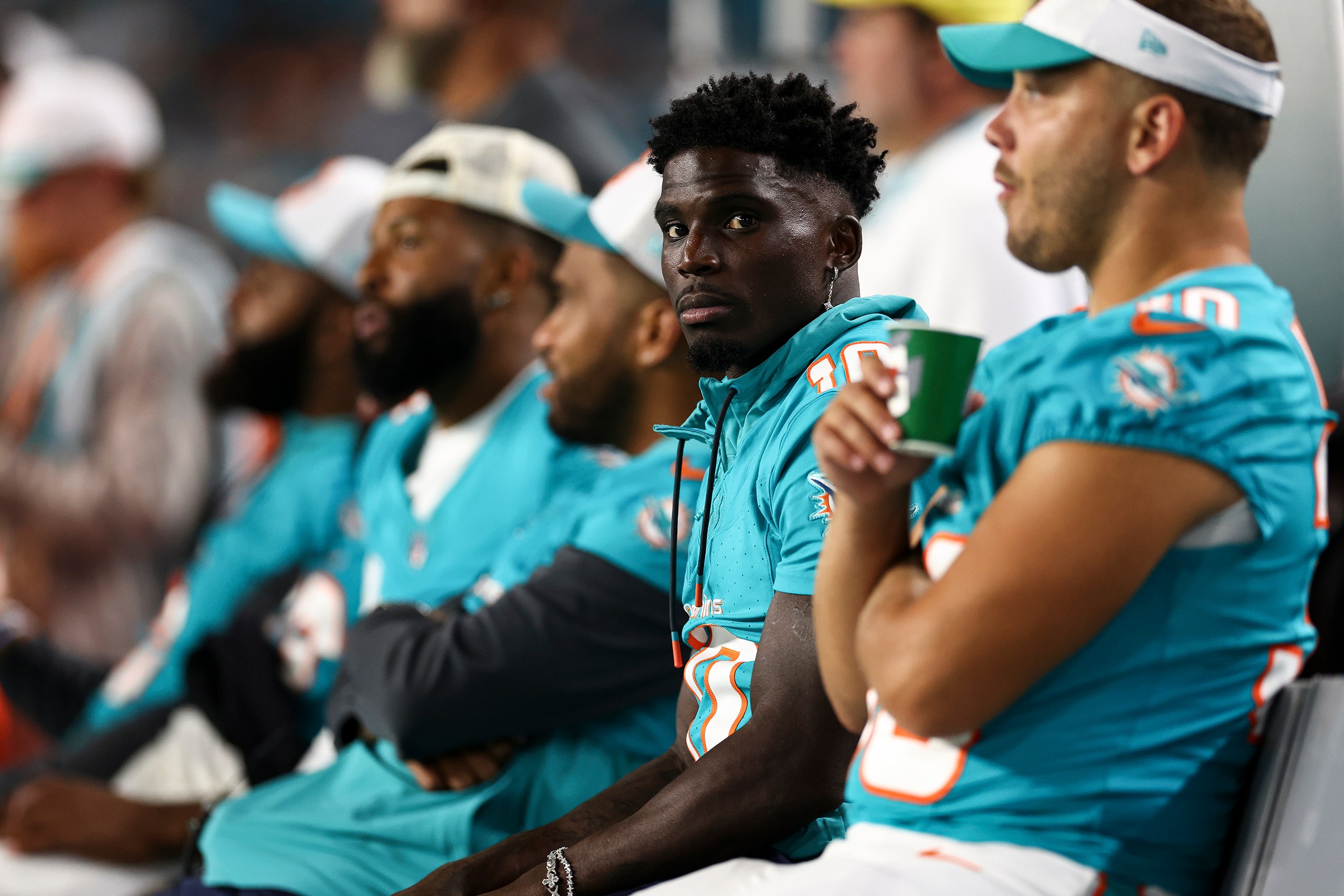 A photo of the football player Tyreek Hill of the Miami Dolphins sitting on the bench at a preseason game.