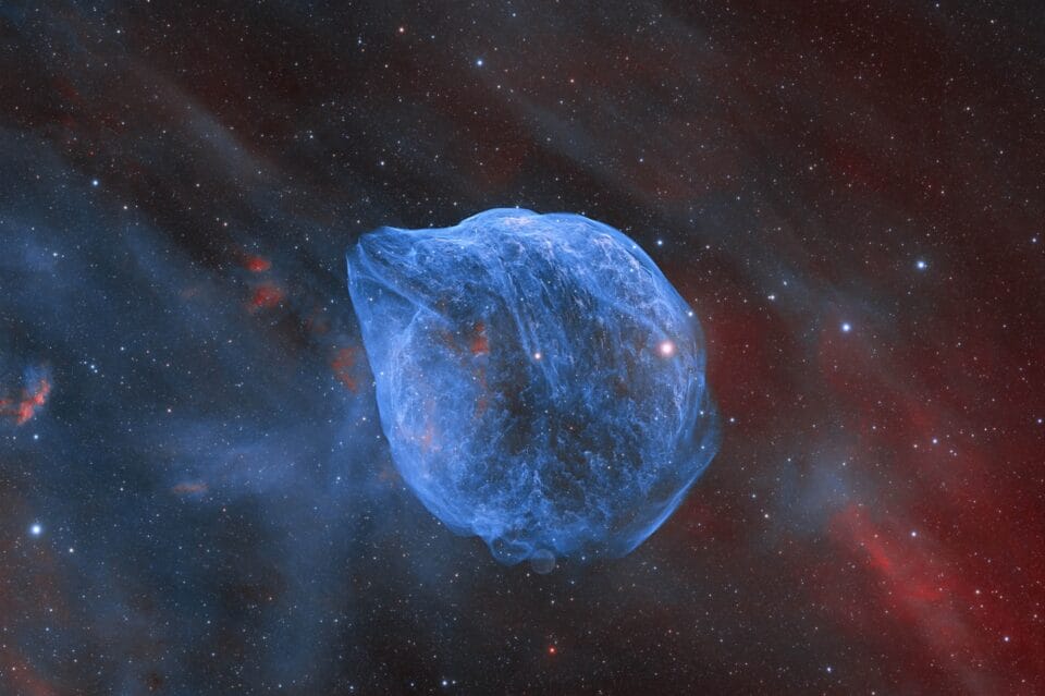 a translucent blue ball in a red and blue starry sky