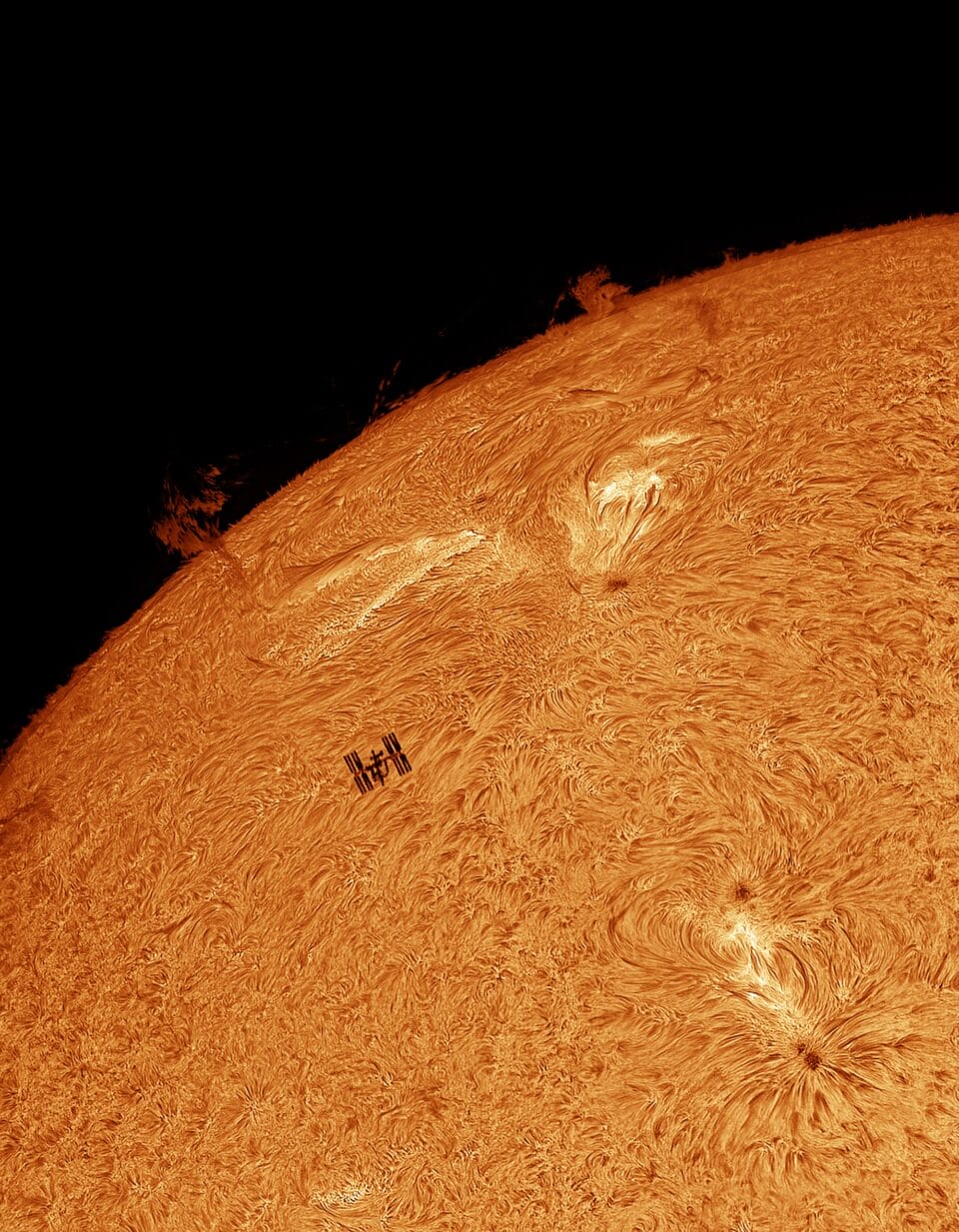 the iss flies in front of the sun that bursts and ripples