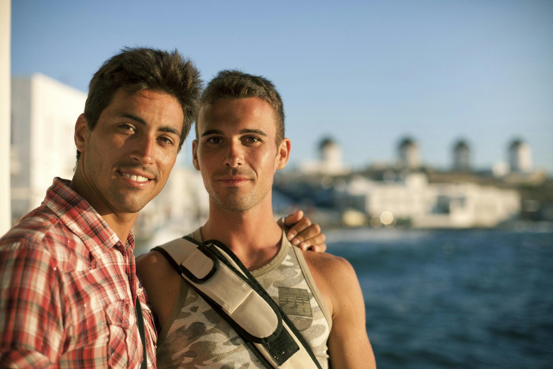 Two men enjoying the sun in Greece and smiling at the camera