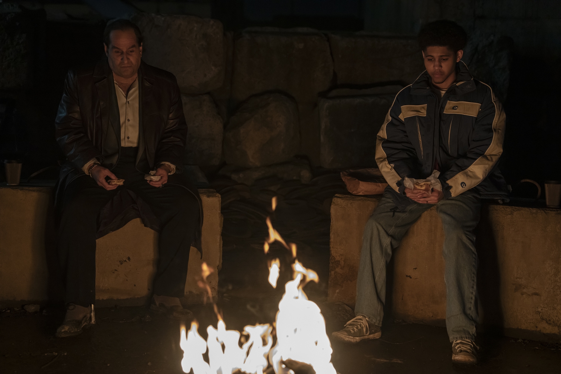 Oz Cobb and Victor sitting around a fire in a still from The Penguin