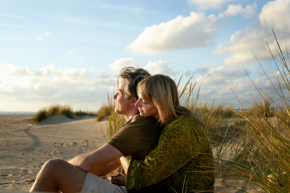 couple sitting embracing on beach