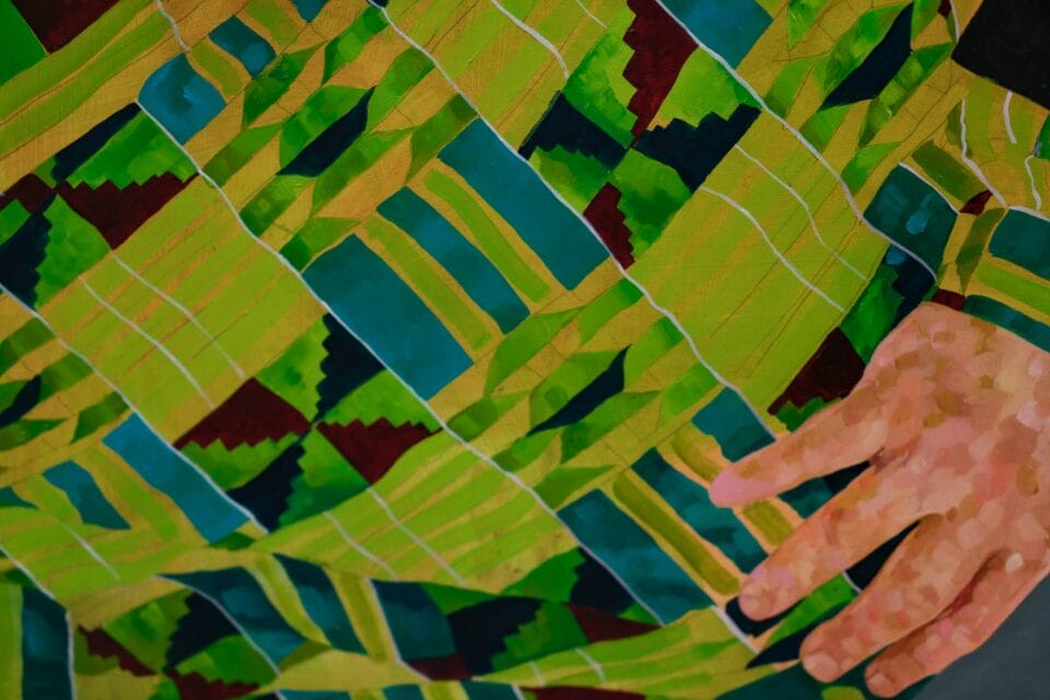 a close up image of a green checked pattern and a hand made of innumerable brushstrokes