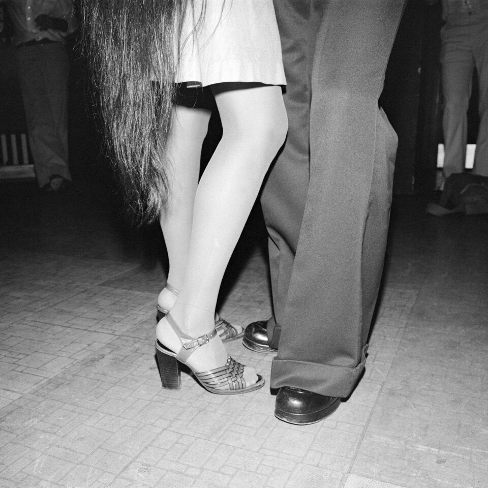 a black and white photograph of two sets of legs as two individuals dance together