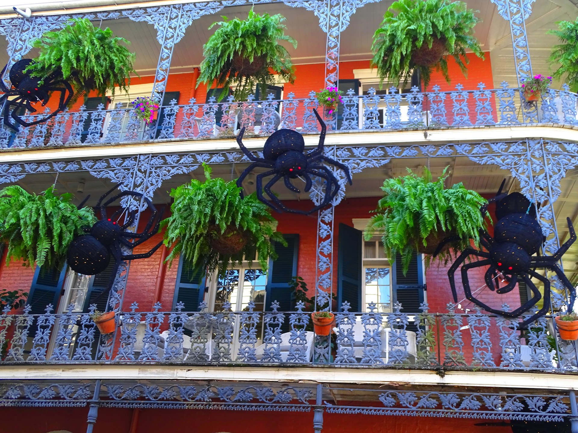 A wrough-iron balcony decorated with giant spiders to mark Halloween