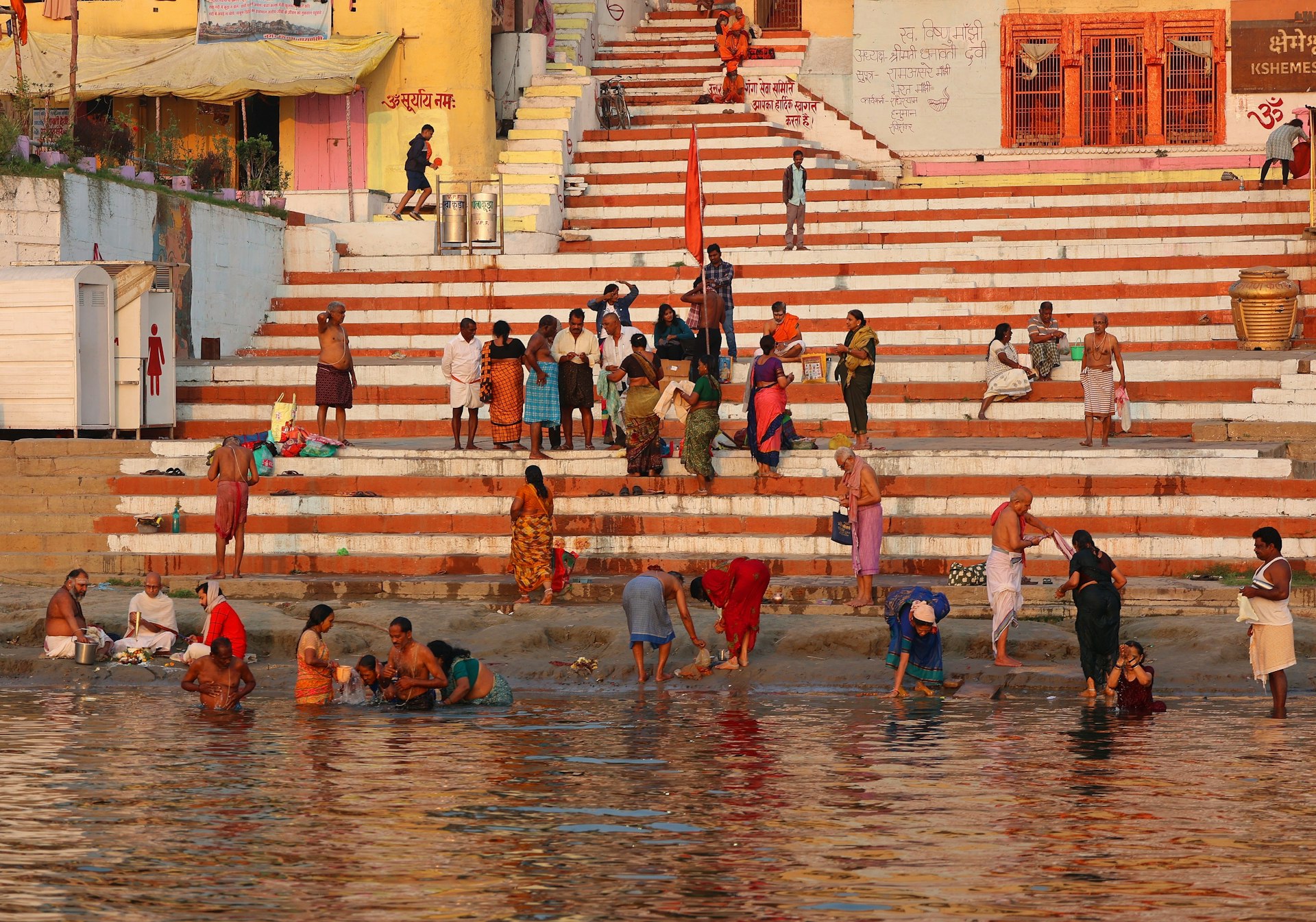 Hindus taking ritual bath along the ghats by the river Ganga in the holy city of Varanasi, India