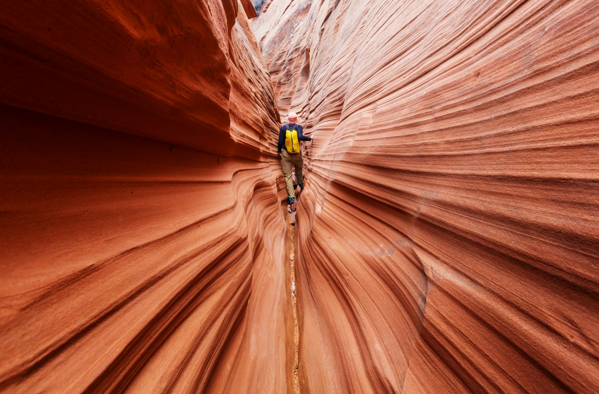 Hiker walking through a slot canyon in Grand Staircase–Escalante National Monument, Utah