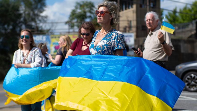 A small group of supporters waved Ukrainian flags during Mr Zelenskyy's visit to the munitions plant. Pic: AP