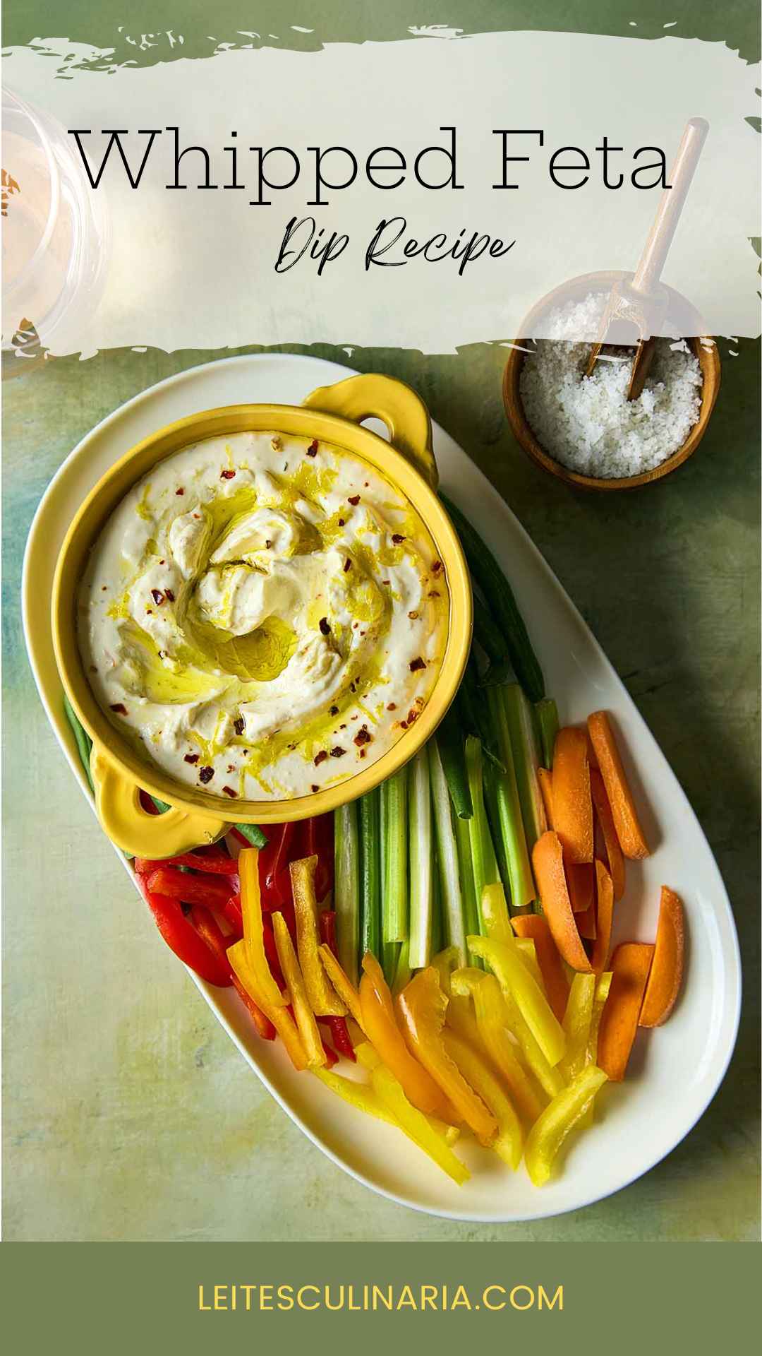 A bowl of whipped feta dip topped with oil and lemon zest on a platter of raw vegetables.