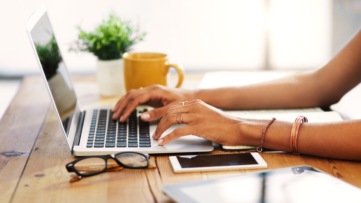 Close up of a woman typing on laptop